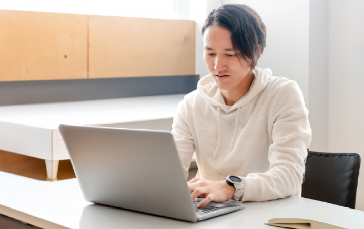 カフェでレポートを書く大学生
